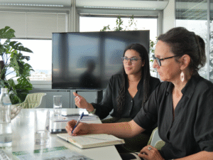 20250804 OeBR Koenigsberger Ludwig c OeBR 10 Zwei Frauen nebeneinander an einem Besprechungstisch, eine spricht, die zweite macht Notizen.