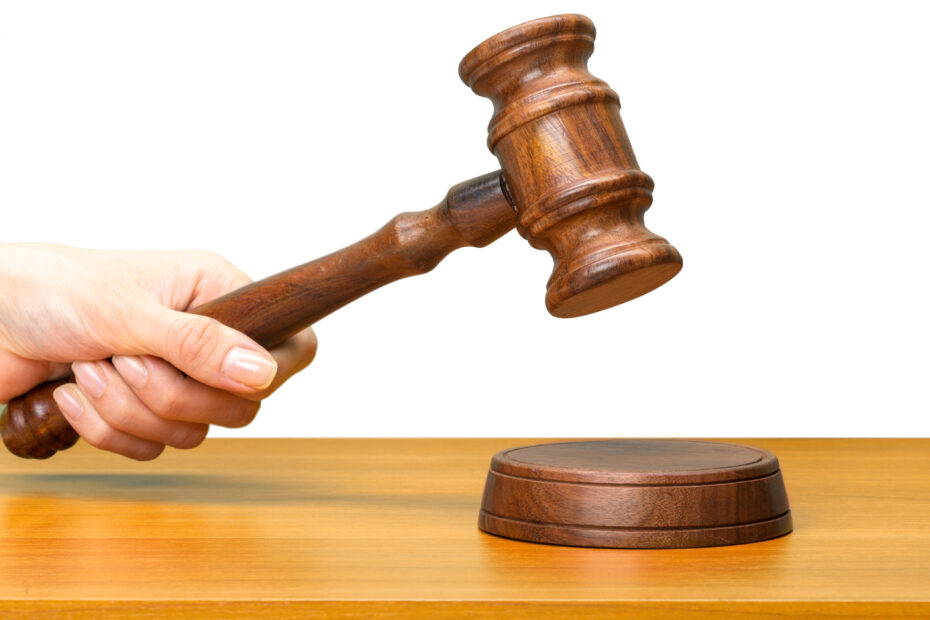 Eine Frau schlägt mit einem Holzhammer auf einen Holzblock